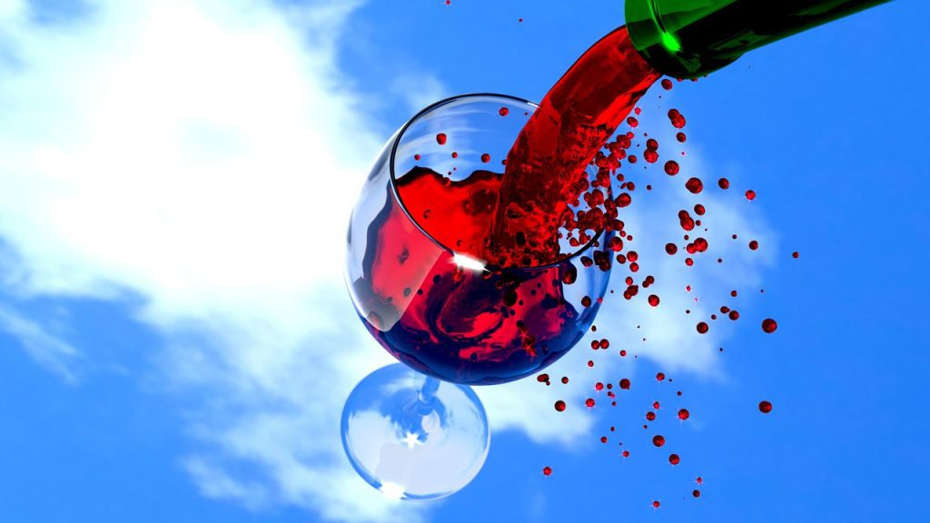 Glas Rotwein mit Himmel im Hintergrund